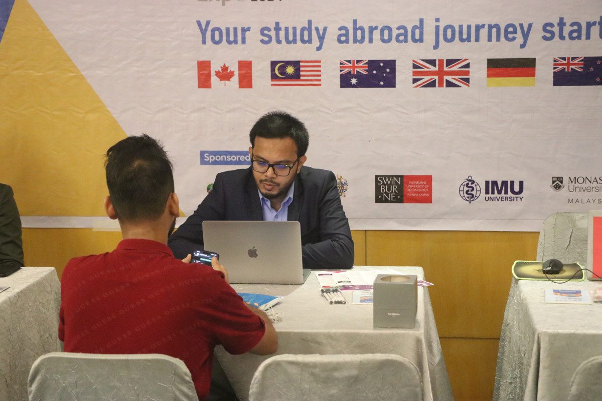 An HIC counsellor talking with students at an education expo